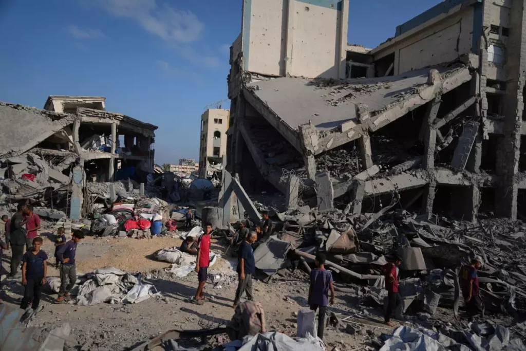 La gente inspecciona los daños en la clínica Sheikh Radwan al-Taba de la UNRWA tras un bombardeo del ejército israelí en la ciudad de Gaza el 6 de agosto de 2025. La clínica había sido evacuada de palestinos desplazados antes del ataque. (AP Foto/Jehad Alshrafi) 