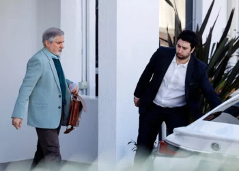 El embajador iraní en Australia, Ahmad Sadeghi (izq.), camina hacia su automóvil dentro de los terrenos de la embajada de la República Islámica de Irán en Canberra el 27 de agosto de 2025 (Hilary Wardhaugh / AFP)