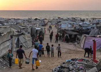 Gazatíes desplazados caminan por un campamento improvisado a lo largo de la playa de la ciudad de Gaza, el 10 de agosto de 2025. (AP Foto/Jehad Alshrafi)