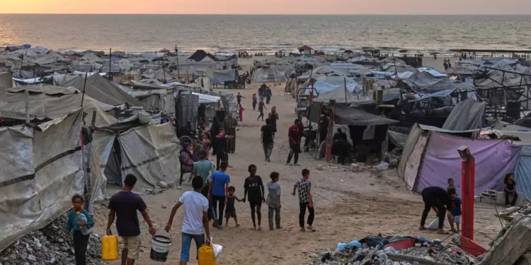 Gazatíes desplazados caminan por un campamento improvisado a lo largo de la playa de la ciudad de Gaza, el 10 de agosto de 2025. (AP Foto/Jehad Alshrafi)