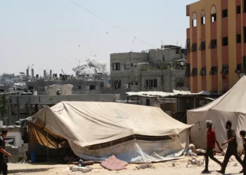 Gazatíes observan cómo el humo se eleva después de un ataque israelí contra un edificio en Yabalia, en el norte de la Franja de Gaza, el 20 de agosto de 2025. (BASHAR TALEB / AFP)
