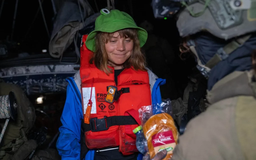 Un soldado israelí ofrece a la activista Greta Thunberg agua y un sándwich de pastrami después de que los militares interceptaran y abordaran el barco en el que ella y otros activistas intentaban romper el bloqueo de Israel a Gaza, la madrugada del 9 de junio de 2025. (Ministerio de Relaciones Exteriores) 