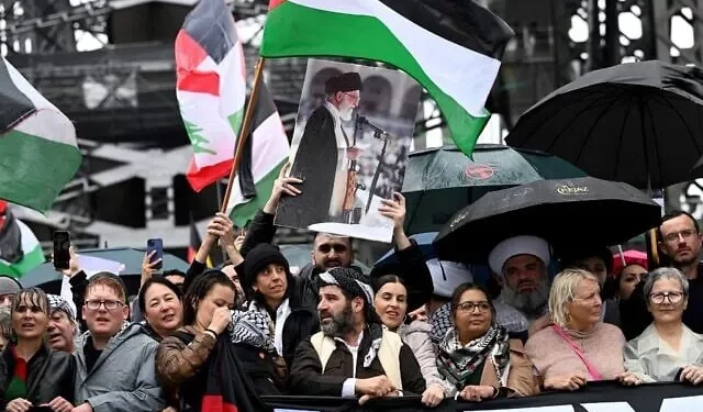Un manifestante levanta un retrato del líder supremo de Irán, el ayatolá Ali Jamenei, al otro lado del puente del puerto de Sídney durante una manifestación propalestina y antiisraelí en Sídney el 3 de agosto de 2025. (Foto de Saeed KHAN / AFP)