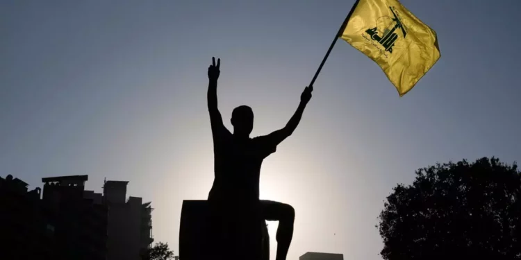 Un partidario de Hezbolá sostiene una bandera de Hezbolá frente a la sede de la Comisión Económica y Social de las Naciones Unidas para Asia Occidental (CESPAO) en Beirut, Líbano, el 26 de julio de 2025. (AP Foto/Bilal Hussein)