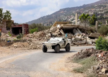 Un vehículo blindado de la Fuerza Provisional de las Naciones Unidas en el Líbano (FPNUL) avanza junto a edificios destruidos a lo largo de una carretera en la aldea de Kfar Kila, en el sur del Líbano, cerca de la frontera con el norte de Israel, el 27 de agosto de 2025. (ANWAR AMRO / AFP)