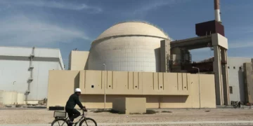 Un trabajador monta en bicicleta frente al edificio del reactor de la central nuclear de Bushehr, en las afueras de la ciudad sureña de Bushehr, Irán, el 26 de octubre de 2010. (Majid Asgaripour/Agencia de Noticias Mehr vía AP)