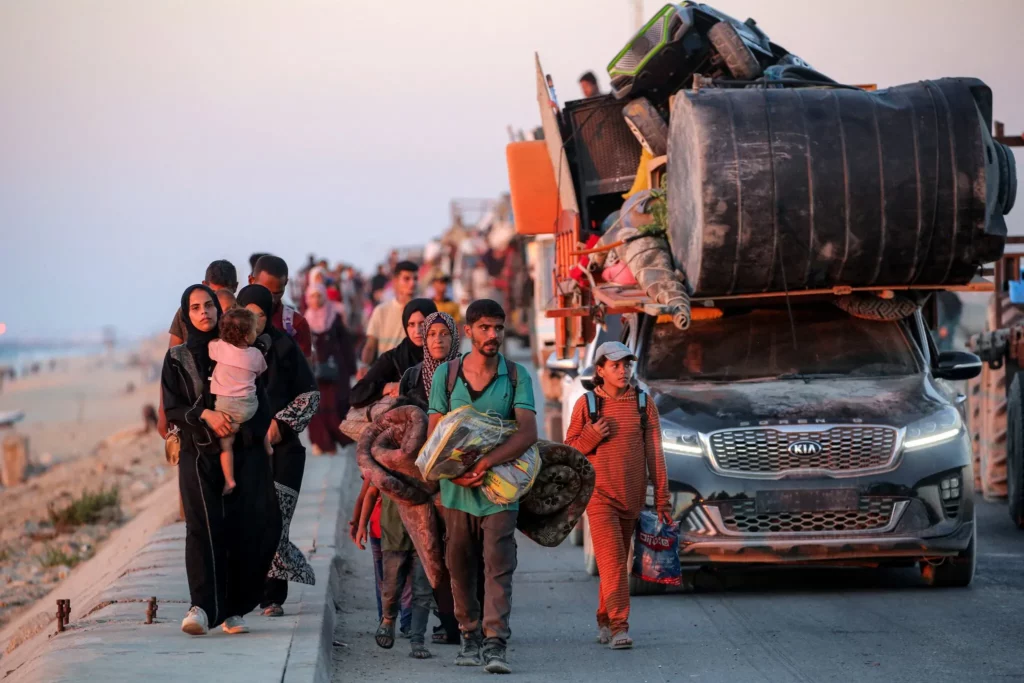 Gazatíes que evacuan hacia el sur de la ciudad de Gaza viajan a pie y en vehículo por la carretera costera de Nuseirat, en el centro de la Franja de Gaza, el 13 de septiembre de 2025. (Eyad BABA / AFP)