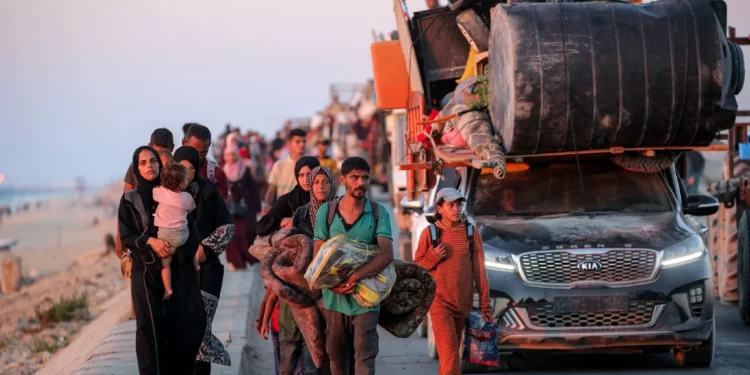 Gazatíes que evacuan hacia el sur de la ciudad de Gaza viajan a pie y en vehículo por la carretera costera de Nuseirat, en el centro de la Franja de Gaza, el 13 de septiembre de 2025. (Eyad BABA / AFP)