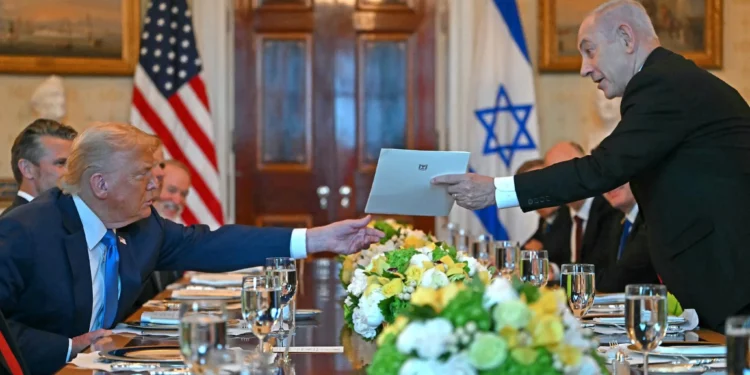 Israeli Prime Minister Benjamin Netanyahu (R) hands over a letter to US President Donald Trump as they meets at the Blue Room of the White House in Washington, DC, on July 7, 2025. (Photo by ANDREW CABALLERO-REYNOLDS / AFP)
