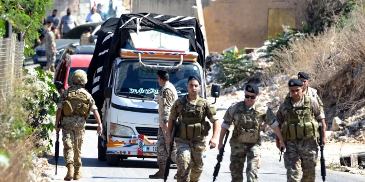 Soldados del ejército libanés hacen guardia mientras un camión cargado de armas sale del campo de refugiados palestinos de Beddawi, cerca de la ciudad norteña de Trípoli, el 13 de septiembre de 2025 (Fathi AL-MASRI / AFP)