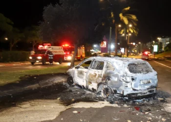 Un automóvil incendiado por residentes árabes israelíes durante los disturbios en la ciudad de Lod, en el centro de Israel, el 11 de mayo de 2021. (Yossi Aloni/FLASH90)