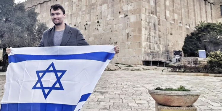 Charlie Kirk sostiene una bandera israelí fuera de la Tumba de los Patriarcas en Hebrón, Judea y Samaria, en una imagen sin fecha (Itamar Ben Gvir/X vía JTA)