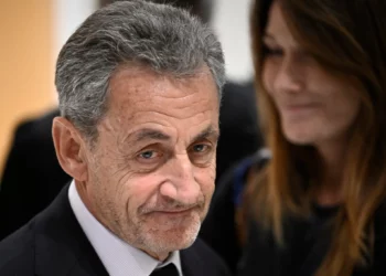 El expresidente francés Nicolas Sarkozy se va junto a su esposa, la cantante franco-italiana Carla Bruni, después del veredicto en su juicio por financiación ilegal de la campaña de Libia para su exitosa candidatura presidencial de 2007, en el Tribunal de París en París, el 25 de septiembre de 2025. (JULIEN DE ROSA / AFP)