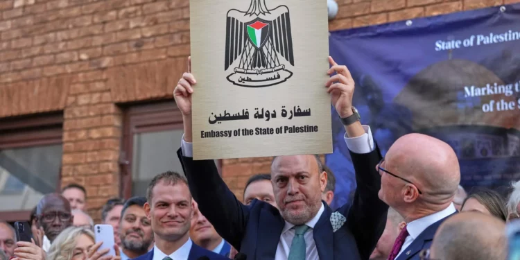 Husam S. Zomlot, embajador de la Misión Palestina en el Reino Unido, sostiene un nuevo cartel durante una ceremonia de izamiento de la bandera palestina en la Misión Palestina en Londres, el lunes 22 de septiembre de 2025. (Foto AP/Frank Augstein)