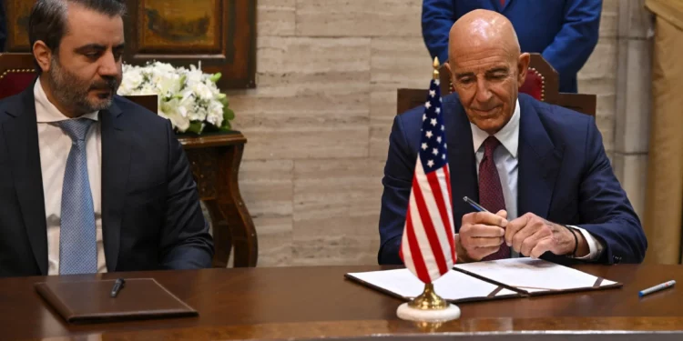 El ministro de Asuntos Exteriores sirio, Asaad al-Shibani (centro), observa cómo el enviado especial de Estados Unidos para Siria, Tom Barrack, se prepara para firmar un acuerdo en Damasco el 16 de septiembre de 2025. (Louai Beshara/AFP)