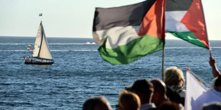 Activistas ondean banderas palestinas mientras se reúnen para apoyar una flotilla que transporta ayuda humanitaria y activistas propalestinos y antiisraelíes en Ajaccio, en la isla mediterránea francesa de Córcega, el 12 de septiembre de 2025 (Pascal POCHARD-CASABIANCA / AFP)