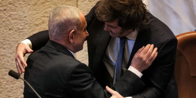 El presidente de Argentina, Javier Milei (der.), abraza al primer ministro de Israel, Benjamin Netanyahu (izq.), durante un evento en el que se dirigió a la Knéset, el 11 de junio de 2025. (Menahem KAHANA / AFP)