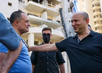 El exprimer ministro Naftali Bennett visita el lugar donde impactó un misil balístico lanzado desde Irán en Petah Tikva, el 18 de junio de 2025. (Jonatha Shaul/Flash90)