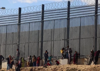 Palestinos junto a la valla fronteriza con Egipto en Rafah, en el sur de la Franja de Gaza, el 24 de enero de 2024. (AFP)