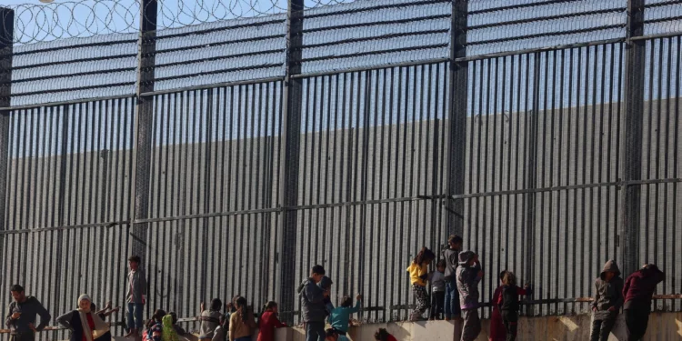 Palestinos junto a la valla fronteriza con Egipto en Rafah, en el sur de la Franja de Gaza, el 24 de enero de 2024. (AFP)