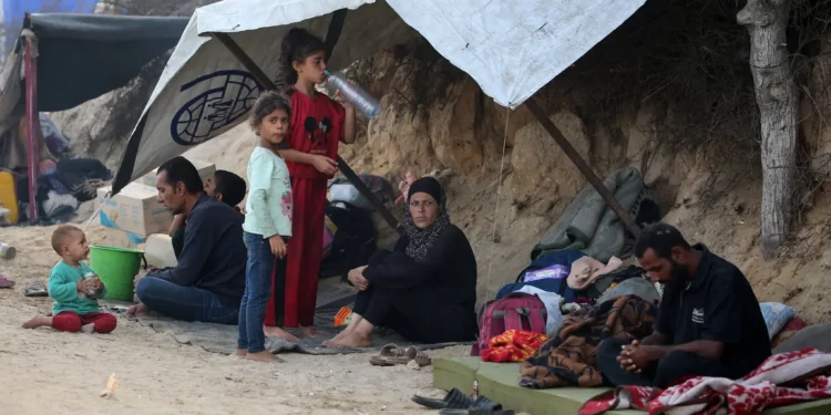 Palestinos que huyeron de la ciudad de Gaza se reúnen bajo la sombra en el campo de refugiados de Nuseirat, en el centro de la Franja de Gaza, el 28 de septiembre de 2025. (Foto de Eyad BABA / AFP)