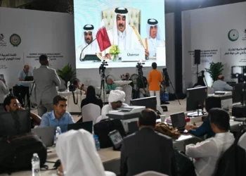 Los periodistas siguen el discurso del emir de Qatar, el jeque Tamim bin Hamad Al-Thani, en el centro de prensa durante la apertura de la cumbre de emergencia árabe-islámica de 2025 en Doha el 15 de septiembre de 2025. (MAHMUD HAMS / AFP)