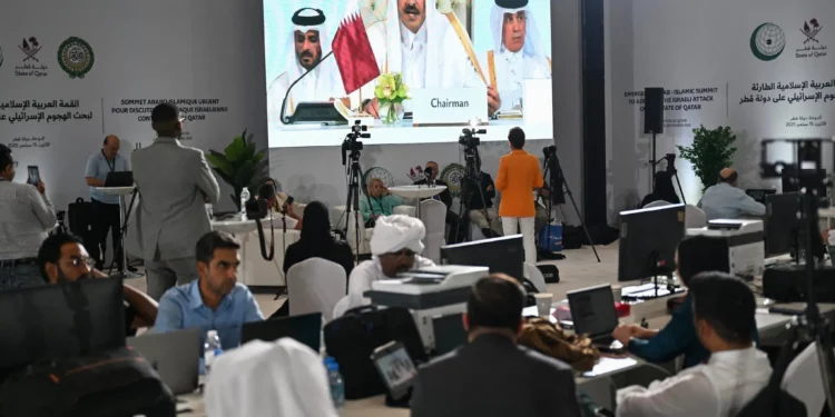 Los periodistas siguen el discurso del emir de Qatar, el jeque Tamim bin Hamad Al-Thani, en el centro de prensa durante la apertura de la cumbre de emergencia árabe-islámica de 2025 en Doha el 15 de septiembre de 2025. (MAHMUD HAMS / AFP)
