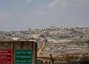 Un cartel militar israelí se encuentra en la frontera entre Israel y Líbano, con el pueblo libanés de Blida al fondo, el 17 de febrero de 2025. (Jalaa MAREY / AFP)
