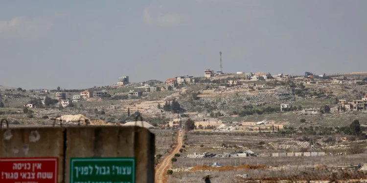 Un cartel militar israelí se encuentra en la frontera entre Israel y Líbano, con el pueblo libanés de Blida al fondo, el 17 de febrero de 2025. (Jalaa MAREY / AFP)