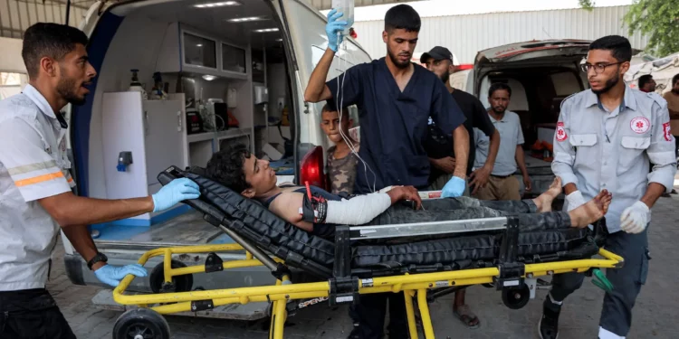Un niño palestino, herido por disparos mientras esperaba los camiones de ayuda que ingresaban al norte de la Franja de Gaza por el cruce de Zikim, es bajado de una ambulancia tras llegar al Hospital Shifa en la ciudad de Gaza para recibir atención médica, el 27 de julio de 2025. (Omar Al-Qattaa/AFP)