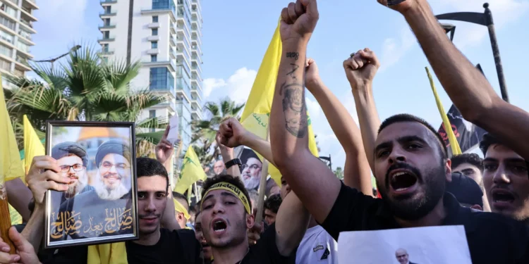 Simpatizantes de Hezbolá izan las banderas amarillas del partido y fotografías de su líder asesinado, Hassan Nasrallah, al conmemorar el primer aniversario de su muerte, en la zona costera de Raouche, en Beirut, el 25 de septiembre de 2025. (Anwar Amro / AFP)