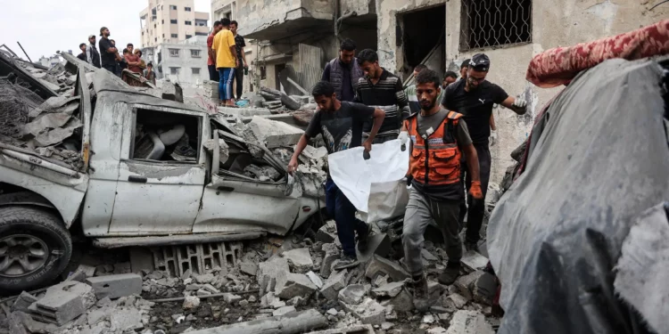 Palestinos recuperan un cuerpo de entre los escombros de una casa destruida en un ataque israelí nocturno en la ciudad de Gaza el 29 de octubre de 2025 (Omar AL-QATTAA / AFP)