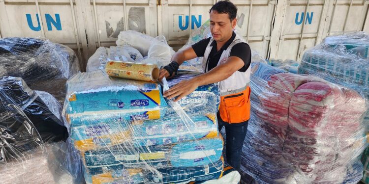 Trabajadores de las Naciones Unidas y de la Media Luna Roja preparan la ayuda para su distribución a los palestinos en un almacén de la UNRWA en Deir al-Balah, Franja de Gaza, el 23 de octubre de 2023. (Foto AP/Hassan Eslaiah)