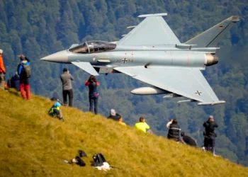 Aficionados de la aviación observan el sobrevuelo de un avión Eurofighter Typhoon de la Fuerza Aérea Alemana durante una exhibición de aviación militar y acrobática cerca de la Cruz de los Héroes en el pico Caraiman, en la cima de las montañas Bucegi, en Busteni, Rumania, el 26 de agosto de 2025. (Foto AP/ Vadim Ghirda)
