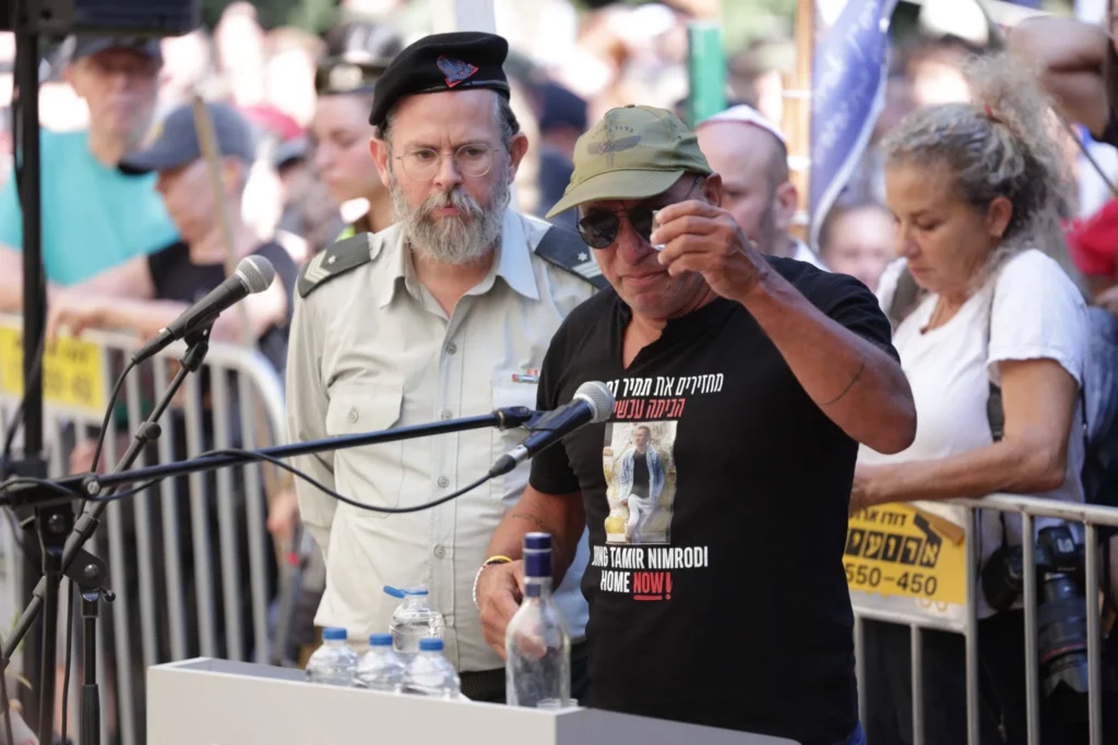 Alon Nimrodi, a la derecha, se prepara para tomar un trago de vodka mientras elogia a su hijo Tamir, que está siendo enterrado en Kfar Saba un día después de que Hamás devolviera su cuerpo, el 16 de octubre de 2025. (Alon Gilboa/Foro de Rehenes) 