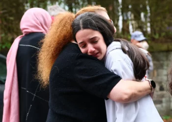 Miembros de la comunidad se consuelan cerca de la Sinagoga de la Congregación Hebrea de Heaton Park en Crumpsall, al norte de Manchester, el 2 de octubre de 2025, tras un mortífero atentado terrorista en la sinagoga. (Paul Currie / AFP)