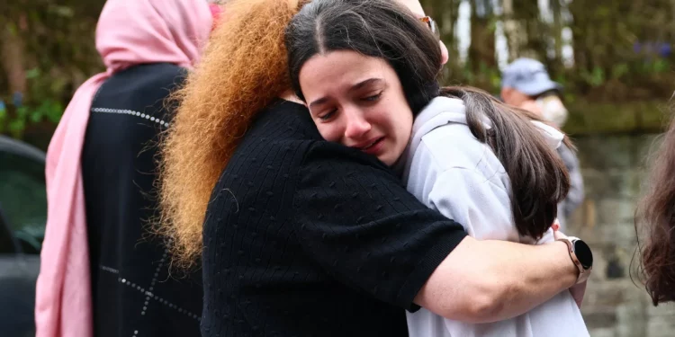 Miembros de la comunidad se consuelan cerca de la Sinagoga de la Congregación Hebrea de Heaton Park en Crumpsall, al norte de Manchester, el 2 de octubre de 2025, tras un mortífero atentado terrorista en la sinagoga. (Paul Currie / AFP)