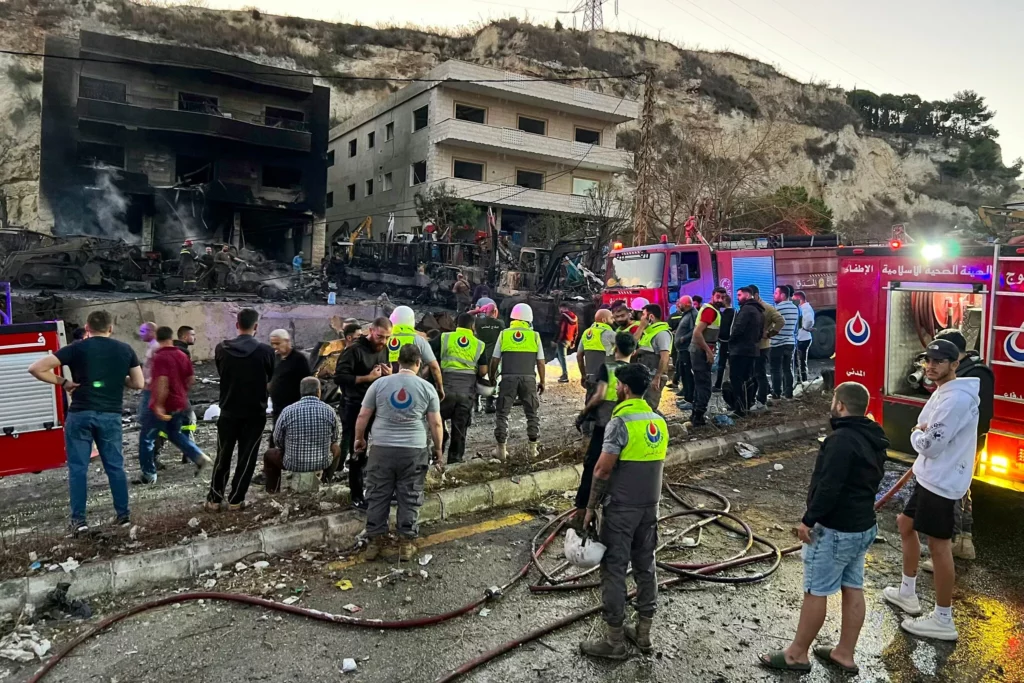 Los rescatistas y los socorristas se encuentran frente a un edificio dañado tras un ataque israelí nocturno en la zona de Al-Msayleh, en el sur del Líbano, el 11 de octubre de 2025. (Mahmoud ZAYYAT / AFP)