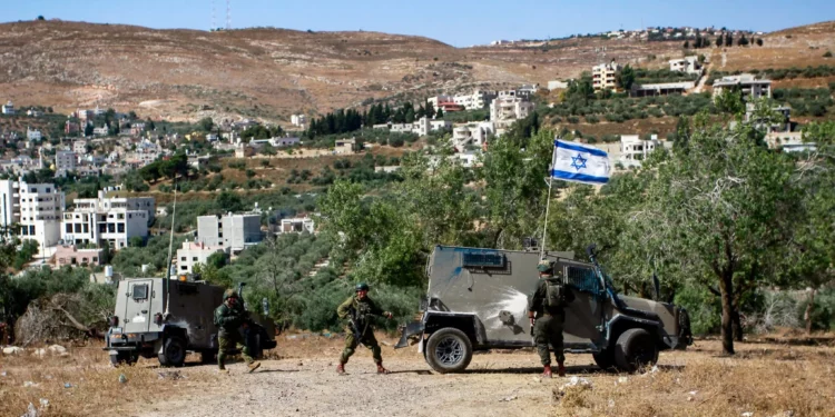 Soldados israelíes custodian la aldea de Burin, cerca de la ciudad de Nablus, en Cisjordania, tras un ataque de colonos judíos el 18 de junio de 2024. (Nasser Ishtayeh/Flash90)