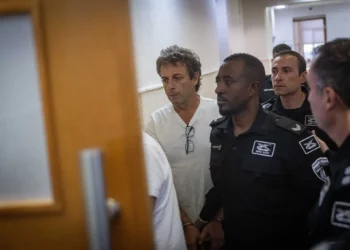 Mark Foigel, uno de los activistas arrestados por incendiar contenedores de reciclaje y un automóvil cerca de la residencia del Primer Ministro, llega a una audiencia en el Tribunal de Distrito de Jerusalén el 26 de octubre de 2025. (Chaim Goldberg/Flash90)