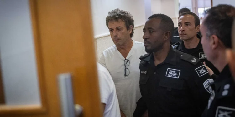 Mark Foigel, uno de los activistas arrestados por incendiar contenedores de reciclaje y un automóvil cerca de la residencia del Primer Ministro, llega a una audiencia judicial en el Tribunal de Distrito de Jerusalén el 26 de octubre de 2025. (Chaim Goldberg/Flash90)