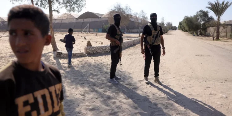 Miembros del ala militar de Hamás montan guardia antes de entregar a los rehenes el 13 de octubre de 2025. (Bashar TALEB / AFP)