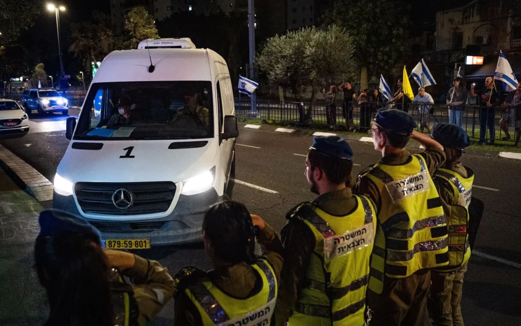 Ciudadanos y soldados israelíes presentan sus respetos mientras un convoy que transporta los cuerpos de los rehenes Inbar Haiman y Muhammad el-Atrash llega al instituto forense Abu Kabir en Tel Aviv, después de que Hamás los transfiriera el 16 de octubre de 2025. (Yonatan Sindel/Flash90) 
