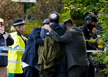 Miembros de la comunidad judía se consuelan cerca de la sinagoga de la Congregación Hebrea de Heaton Park, en Crumpsall, Manchester, Inglaterra, el 2 de octubre de 2025. (Peter Byrne/PA vía AP)
