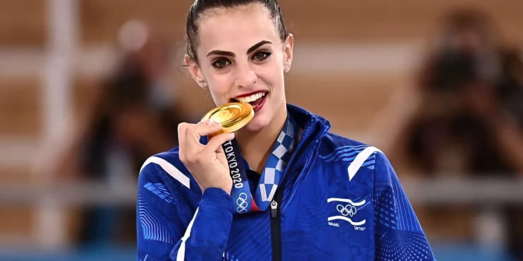 La israelí Linoy Ashram posa con su medalla de oro durante la ceremonia del podio de la final individual de la prueba de gimnasia rítmica, durante los Juegos Olímpicos de Tokio 2020 en el centro de gimnasia Ariake en Tokio, el 7 de agosto de 2021. (Lionel Bonaventure/AFP)