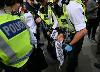 Policía de Londres arresta a seis por apoyar grupo propalestino prohibido La policía de Londres detuvo a seis personas por mostrar respaldo a Acción Palestina, un grupo propalestino y antiisraelí prohibido, y retiró a manifestantes que se habían reunido para una protesta pese a las solicitudes de cancelación tras un ataque mortal en Manchester. Los arrestos se realizaron mientras los manifestantes se concentraban en Trafalgar Square para expresar su apoyo al grupo bajo las leyes antiterroristas. El ataque en Manchester dejó dos muertos el jueves. La policía abatió al agresor, un ciudadano británico de ascendencia siria, quien según investigaciones antiterroristas podría haber actuado motivado por la ideología islamista extremista. La respuesta policial se produjo inmediatamente después del ataque, en coordinación con las autoridades locales y bajo protocolos de seguridad nacional. Los organizadores de la manifestación ignoraron los pedidos de la policía y del gobierno de suspender el evento, previamente anunciado para protestar contra la prohibición de Acción Palestina. Cientos de personas asistieron a la concentración en Trafalgar Square, donde los activistas sentados mostraban pancartas con lemas de respaldo al grupo. Entre los espectadores se escucharon gritos de “¡Qué vergüenza!” dirigidos a los agentes.