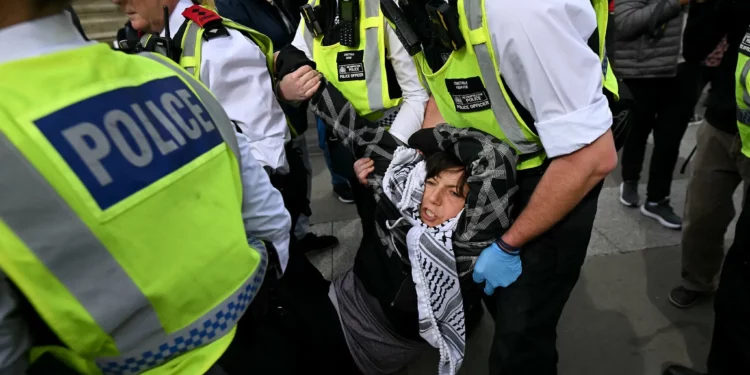 Policía de Londres arresta a seis por apoyar grupo propalestino prohibido La policía de Londres detuvo a seis personas por mostrar respaldo a Acción Palestina, un grupo propalestino y antiisraelí prohibido, y retiró a manifestantes que se habían reunido para una protesta pese a las solicitudes de cancelación tras un ataque mortal en Manchester. Los arrestos se realizaron mientras los manifestantes se concentraban en Trafalgar Square para expresar su apoyo al grupo bajo las leyes antiterroristas. El ataque en Manchester dejó dos muertos el jueves. La policía abatió al agresor, un ciudadano británico de ascendencia siria, quien según investigaciones antiterroristas podría haber actuado motivado por la ideología islamista extremista. La respuesta policial se produjo inmediatamente después del ataque, en coordinación con las autoridades locales y bajo protocolos de seguridad nacional. Los organizadores de la manifestación ignoraron los pedidos de la policía y del gobierno de suspender el evento, previamente anunciado para protestar contra la prohibición de Acción Palestina. Cientos de personas asistieron a la concentración en Trafalgar Square, donde los activistas sentados mostraban pancartas con lemas de respaldo al grupo. Entre los espectadores se escucharon gritos de “¡Qué vergüenza!” dirigidos a los agentes.