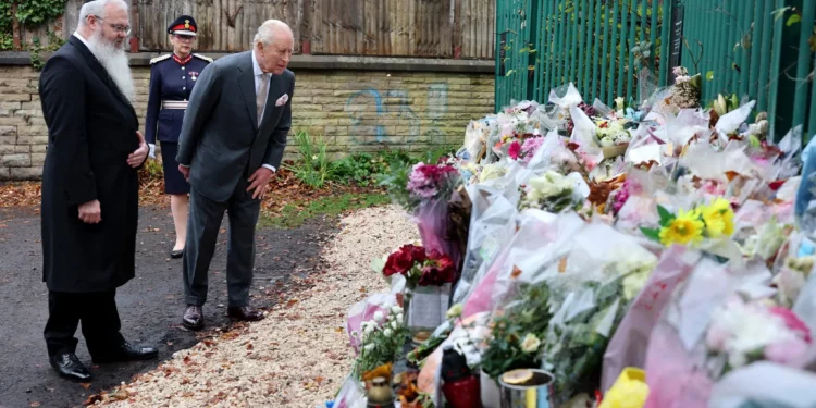 El rey Carlos III de Gran Bretaña observa ramos de flores durante una visita a la sinagoga de la Congregación Hebrea de Heaton Park en Crumpsall, al norte de Manchester, el 20 de octubre de 2025. El 2 de octubre de 2025, un atacante atropelló con un coche a una multitud congregada frente a la sinagoga antes de apuñalarla, matando a dos personas y dejando a tres heridas. (Foto de Chris Jackson / POOL / AFP)