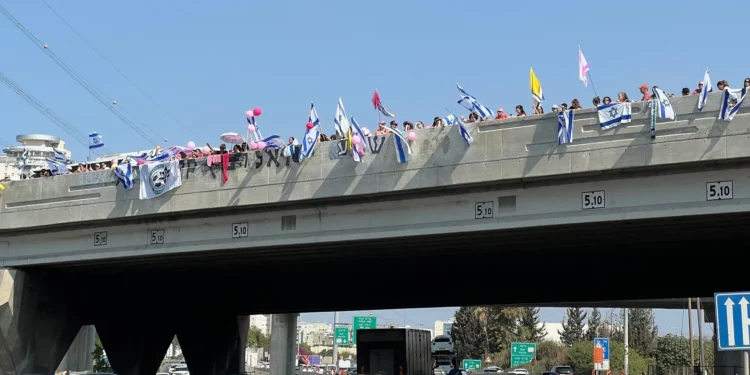 Multitudes se congregan en el puente Aluf Sade sobre la autopista 4 en dirección a Petah Tikvah, a la espera del cortejo fúnebre de Inbar Haiman, vestida de rosa en honor a su apodo, Pink, el 1 de octubre de 2025. (Yael Gadot/Movimiento de Protesta Prodemocrática de Israel)