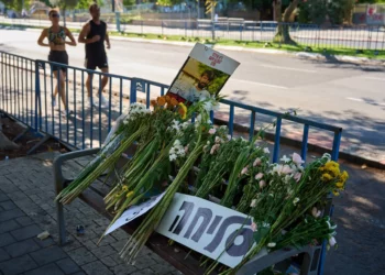 Flores y un cartel escrito en hebreo que dice “Lo siento” se colocan en un banco afuera de Abu Kabir, el instituto forense donde se lleva a cabo el proceso de identificación de los cuatro cuerpos de rehenes entregados por Hamás en la Franja de Gaza, en Tel Aviv, el 14 de octubre de 2025. (Foto AP/Emilio Morenatti)
